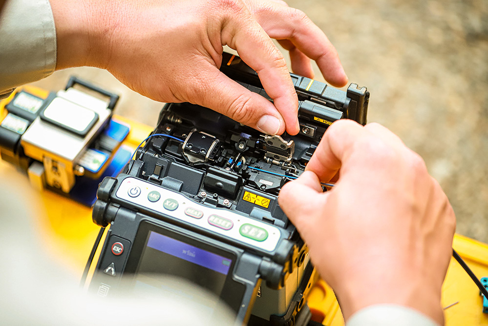 Close up of fibre optic specialist manually splicing cable